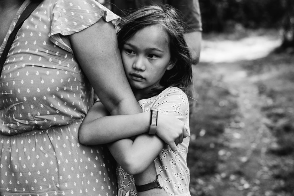 Portrait of daughter hugging mother by Emma Collins