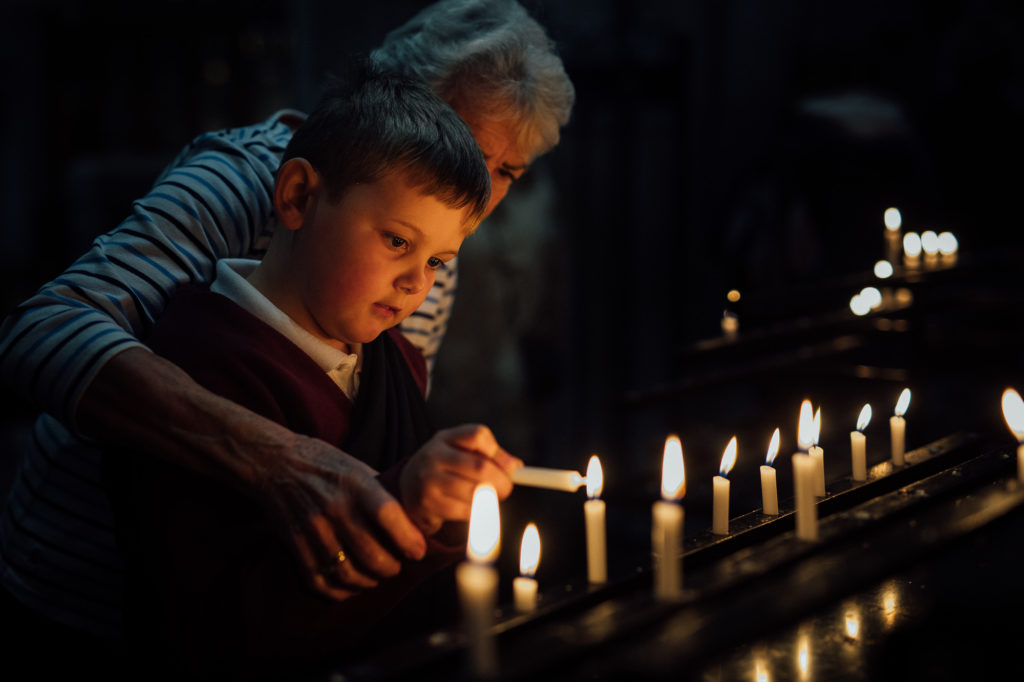 Boy lighting candle with grandma in St Albans Cathdral
