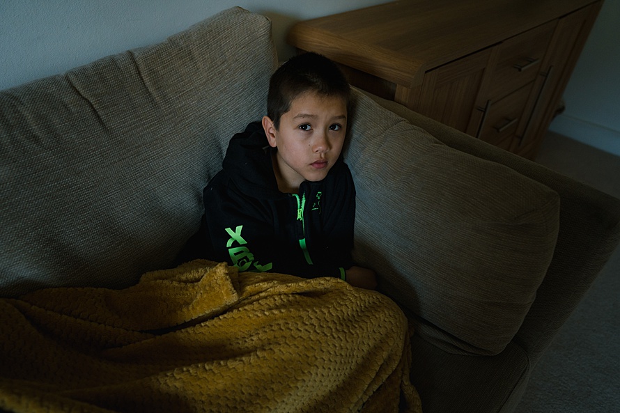 Environmental portrait of boy in pyjamas on family photoshoot in Cambridge
