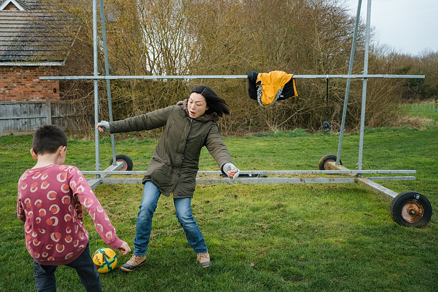 Cambridge documentary family photographer captures mother playing football with son