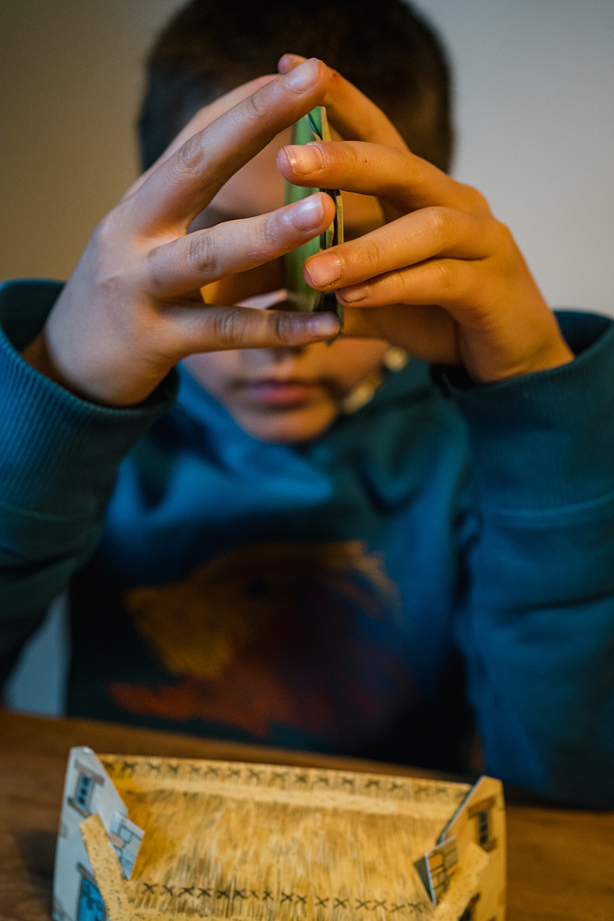 Photo of boy playing board game during documentary family photo session in Cambridge