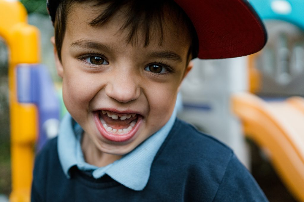 Portrait of little boy in cap with a big smile