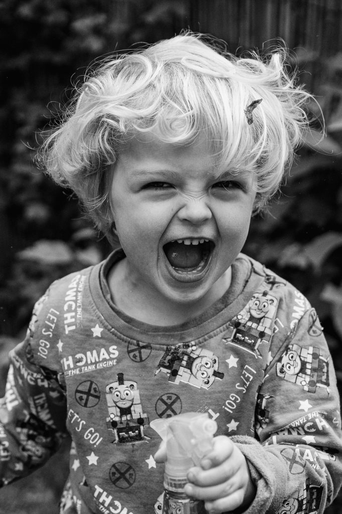 Portrait of a little boy squealing with delight, St Albans natural family photographer