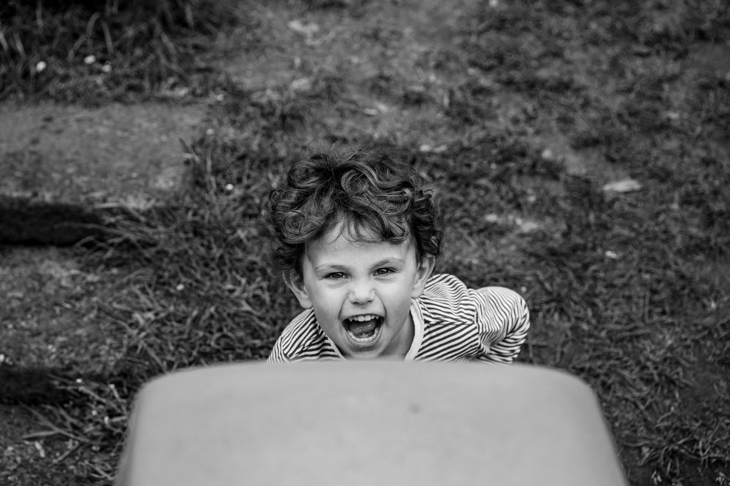 Little boy laughing and shouting, unposed nursery photography