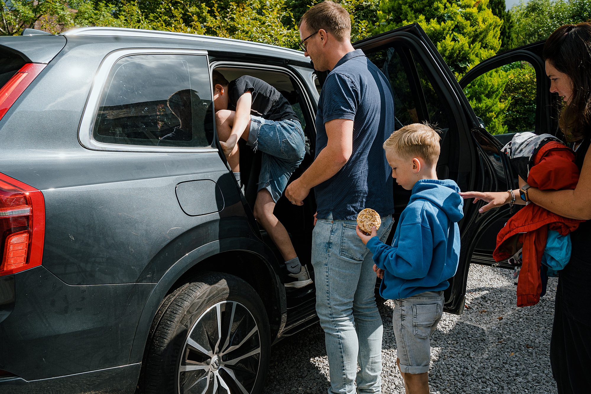 Family of 6 queuing to get in the car, real life family documentary photography UK