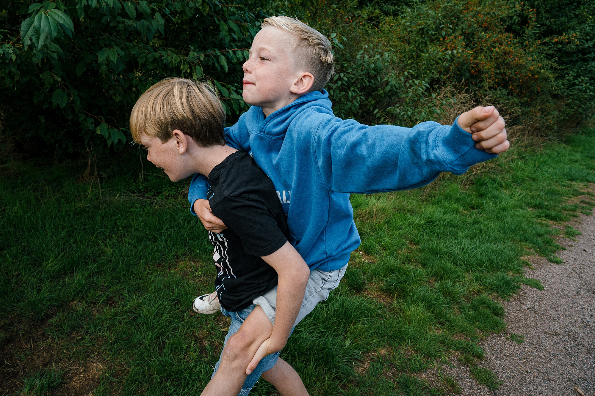 Brothers playing piggy back unposed family photography by Emma Collins