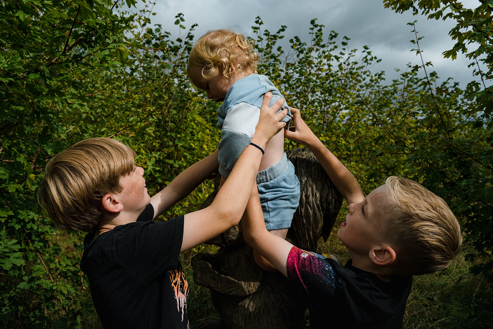 Big brothers helping baby brother sweet moment on family documentary photography session in St Albans